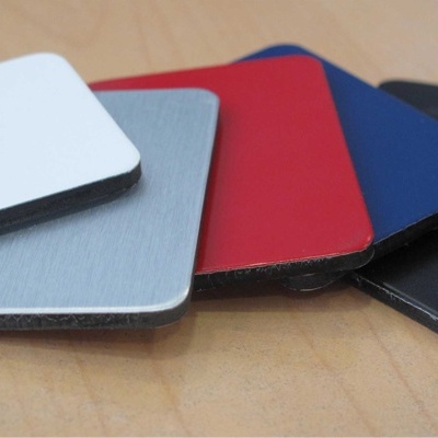 Amostras retangulares coloridas de material com acabamento liso sobre mesa de madeira