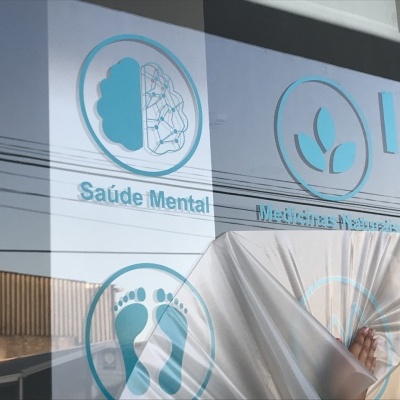 Reflexo em vidro com ícones azuis e texto sobre saúde mental e pegadas