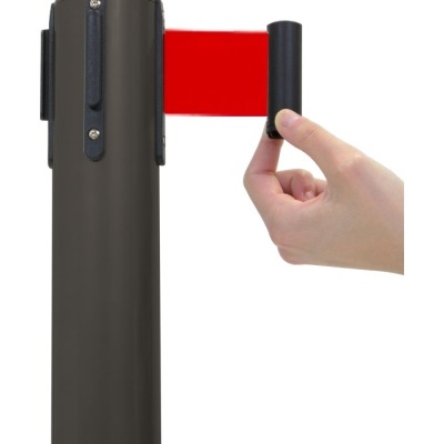 Coluna metálica cinzenta com fita retrátil vermelha puxada por mão