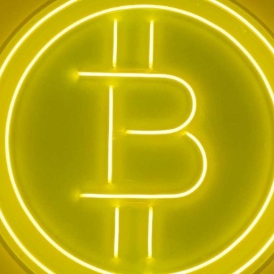 Símbolo de Bitcoin em neon amarelo num fundo amarelo.
