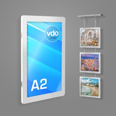 Painel digital branco com ecrã azul 'vdo STORE A2' e três quadros suspensos com fotografias de paisagens urbanas e praianas