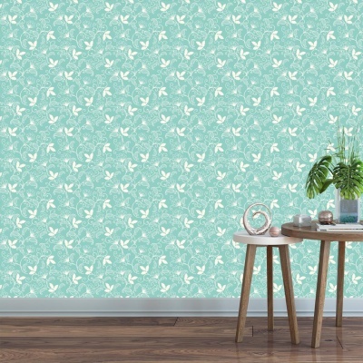 Papel de parede verde água com borboletas brancas e mesas de madeira com planta e decoração.