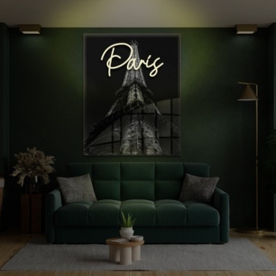 Sala com sofá verde escuro, quadro preto da Torre Eiffel com texto 'Paris', candeeiro dourado e planta