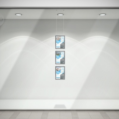 vitrine de loja vazia com três cartazes idênticos e iluminação por focos