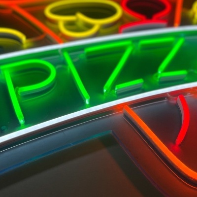 Placa de néon multicolorida com a palavra PIZZA em verde