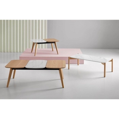 Conjunto de três mesas com tampo em madeira clara e mármore branco e pernas de madeira, dispostas em ambiente minimalista.