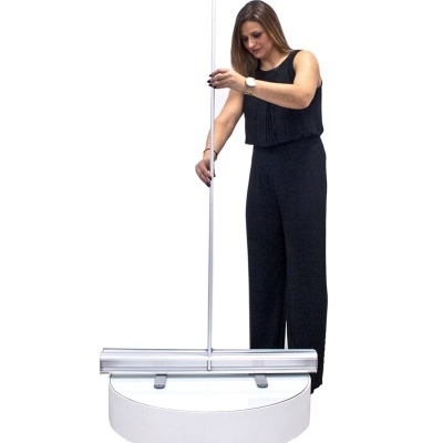 Mulher com roupa preta ajusta uma estrutura metálica prateada com base branca