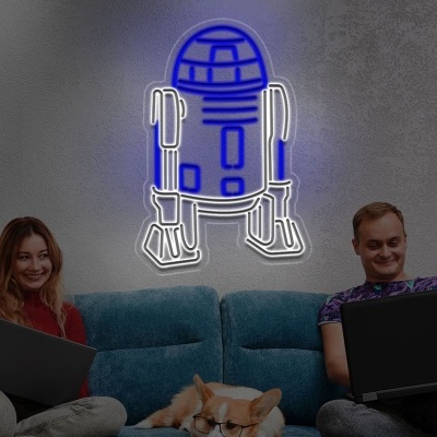 Sofá azul com duas pessoas, portátil e letreiro de néon de R2-D2 na parede cinzenta