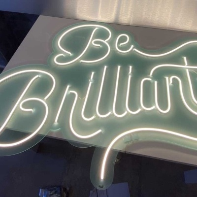 Luminária texto iluminado Be Brilliant em fundo verde