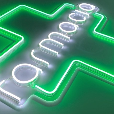 Letreiro luminoso de néon verde em forma de cruz com texto branco