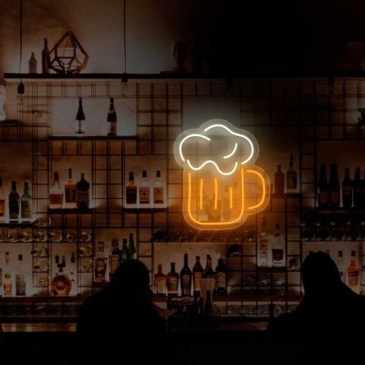 Bar com prateleiras de garrafas e luz de néon de caneca de cerveja