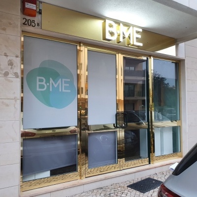 Fachada de loja com letras B·ME e moldura dourada