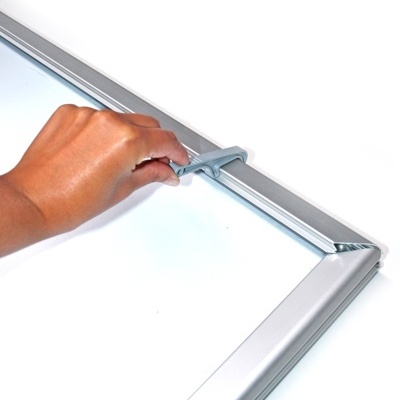 Mão a abrir ou fechar moldura de metal prateada com mecanismo cinzento