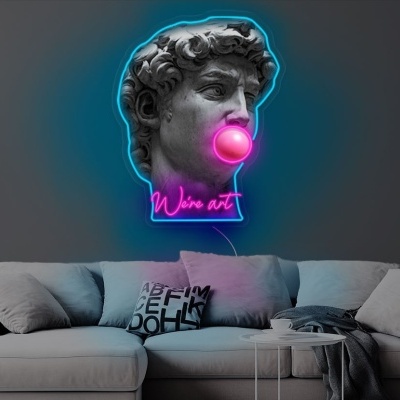 Cabeça de estátua clássica com bola de chiclete rosa em parede cinzenta sobre sofá