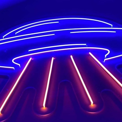 Iluminação de néon em forma de disco voador azul e rosa