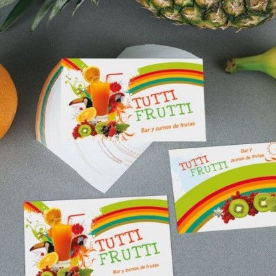 Cartões de visita coloridos com ilustrações de frutas e texto TUTTI FRUTTI perto de frutas frescas