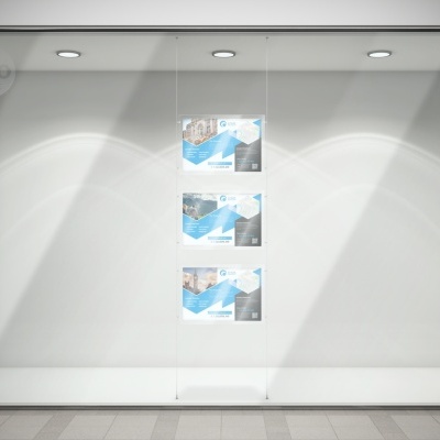 Vitrine iluminada com três cartazes pendurados no vidro