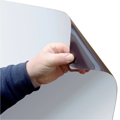 Mão segurando filme adesivo preto numa superfície prateada refletiva