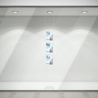 Montra de loja vazia com três cartazes verticais no centro