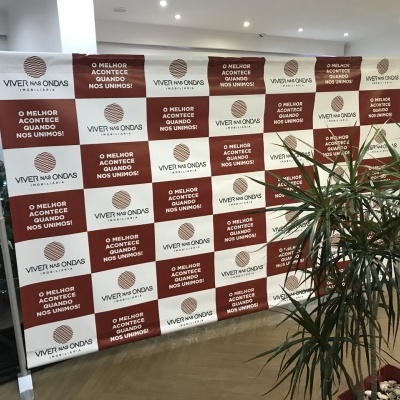 Painel publicitário quadriculado com textos e logótipos em ambiente decorado