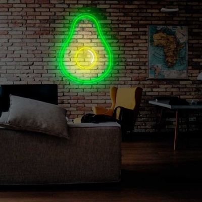 Sala de estar com sofá cinza, cadeira amarela, parede de tijolos com luminária de neon verde em forma de lâmpada e quadro ao fundo