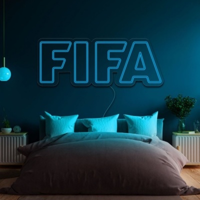 Quarto com cama, almofadas azuis e luz de néon FIFA na parede azul escura