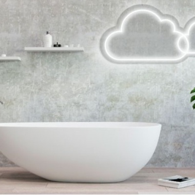 Banheira branca oval com parede cinza, prateleiras, luz em forma de nuvem e planta verde