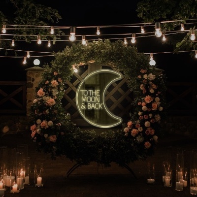 cenário ao ar livre com guirlanda de folhagem, flores, néon e velas