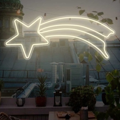 decoração luminosa de estrela cadente neon branca num ambiente urbano externo à noite