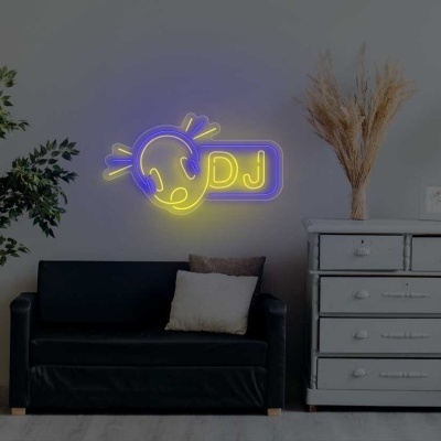 Sala com sofá preto, cómoda cinza, candeeiro e placa luminosa com texto 'DJ'.