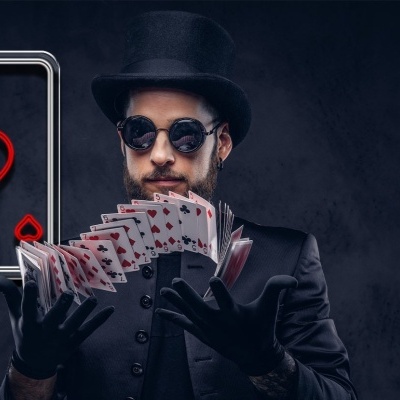 Homem com chapéu e luvas pretas a manipular cartas de baralho vermelho e branco