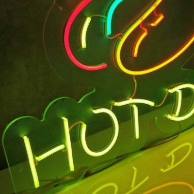 Sinal de néon 'HOT DOG' em verde e amarelo com reflexo