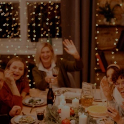 Grupo de pessoas felizes à mesa de jantar festiva com decoração natalina