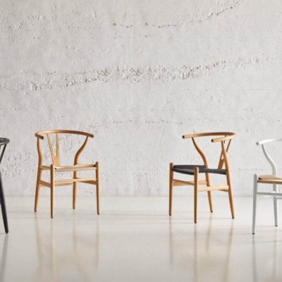 Quatro cadeiras modernas de madeira em várias cores com almofadas em ambiente minimalista