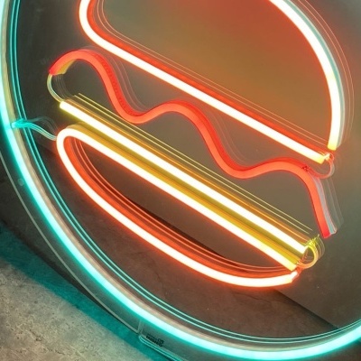 Placa de néon redonda com imagem de hambúrguer em cores brilhantes