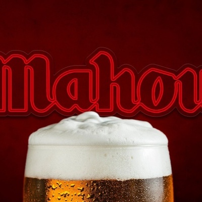 Copo de cerveja com espuma e o logo MAHOU em fundo vermelho