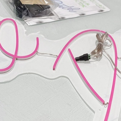 Letreiro de neon cor-de-rosa com texto Tie Death em suporte transparente