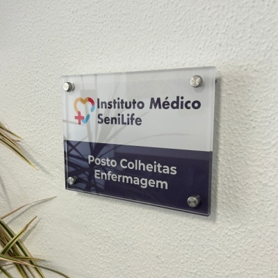 Placa de sinalização acrílica do Instituto Médico SeniLife na parede com texto de Posto Colheitas Enfermagem.