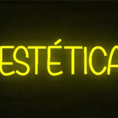 Letreiro neon amarelo com palavra ESTÉTICA em fundo preto
