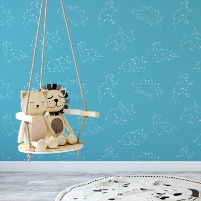 Baloiço de madeira com peluches de gato e leão, fundo parede azul com constelações e tapete redondo branco com padrão preto.