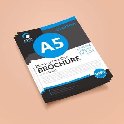 Brochuras A5 com design preto, azul e branco sobre superfície bege