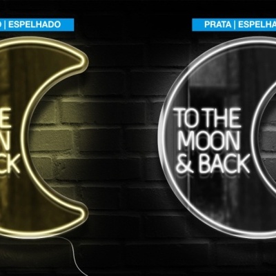 Dois sinais de néon em forma de lua com texto 'TO THE MOON & BACK' em ouro e prata espelhados