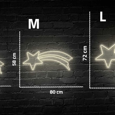 Três sinais de estrela cadente iluminada em três tamanhos diferentes contra parede de tijolos