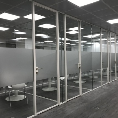 Divisórias de vidro com faixa fosca num escritório moderno.