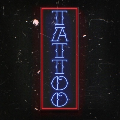 Placa de néon vertical com a palavra TATTO em azul e contorno vermelho