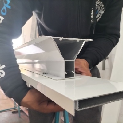 Estrutura metálica branca encaixada, segura por pessoa em ambiente interior