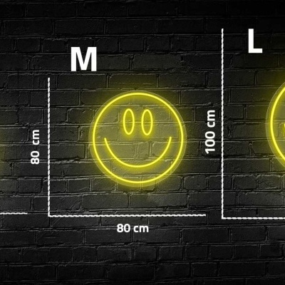 Luzes LED amarilhas em forma de smiley de vários tamanhos numa parede de tijolos.