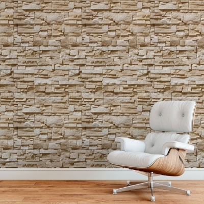 Poltrona branca com estrutura de madeira clara e base metálica diante de parede de pedra bege.