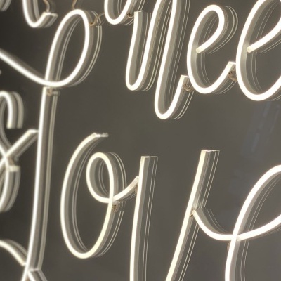 Letreiro luminoso em néon branco com a frase 