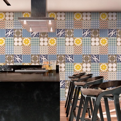 Cozinha com balcão preto e bancos altos com azulejos coloridos na parede